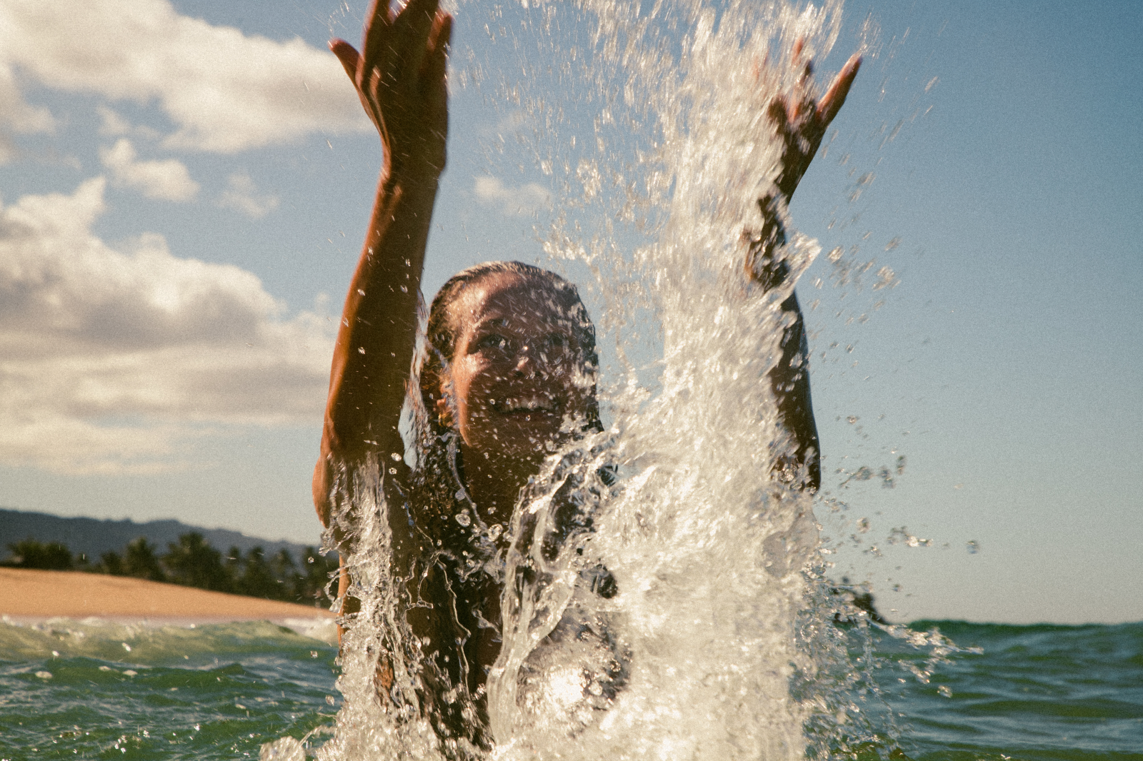 female model splashing water in ocean